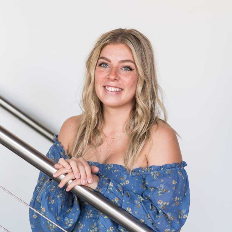 Portrait of Destinee, a professional stylist at Revolutions Salon, showcasing their expertise and style.