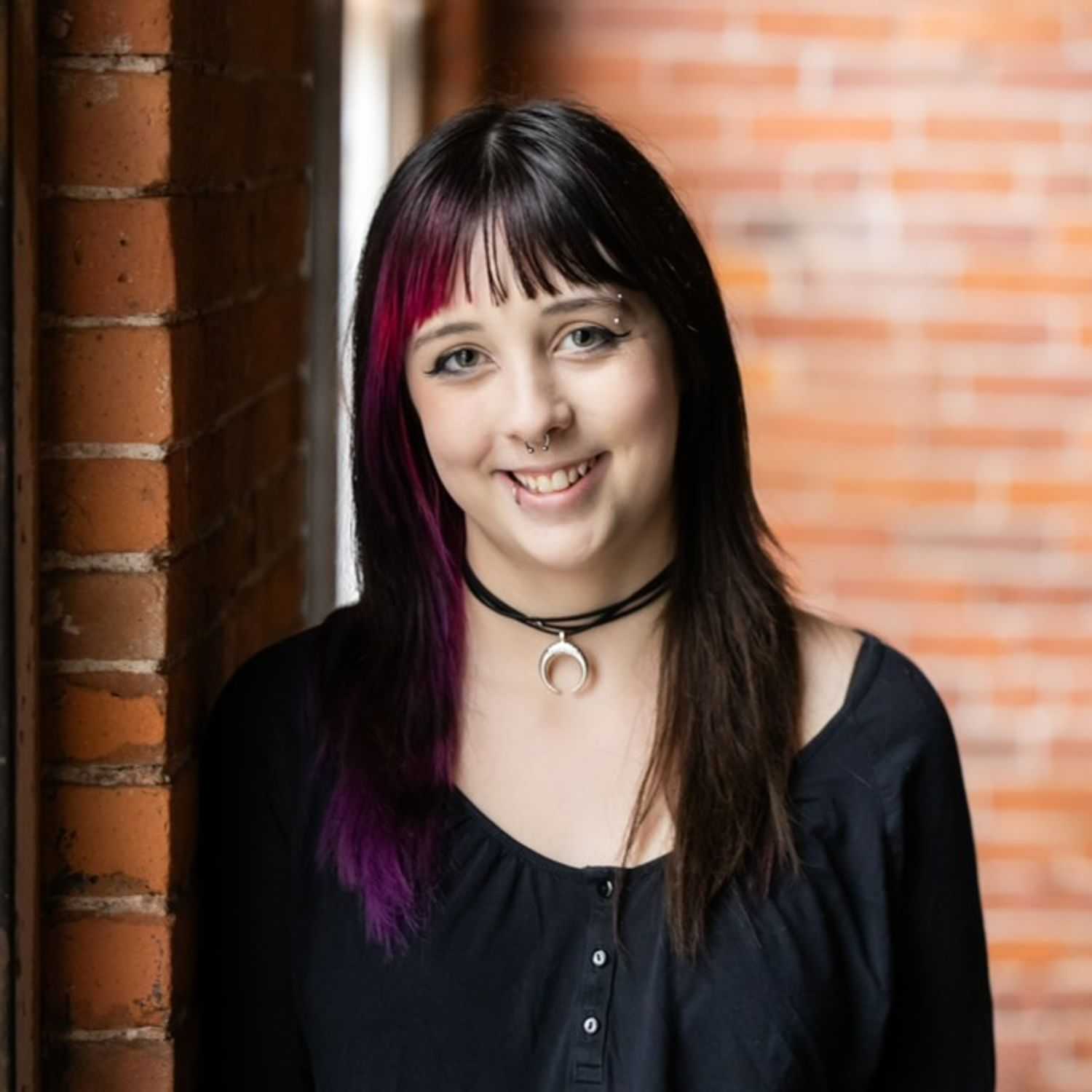 Portrait of Emry, a professional stylist at Revolutions Salon, showcasing their expertise and style.