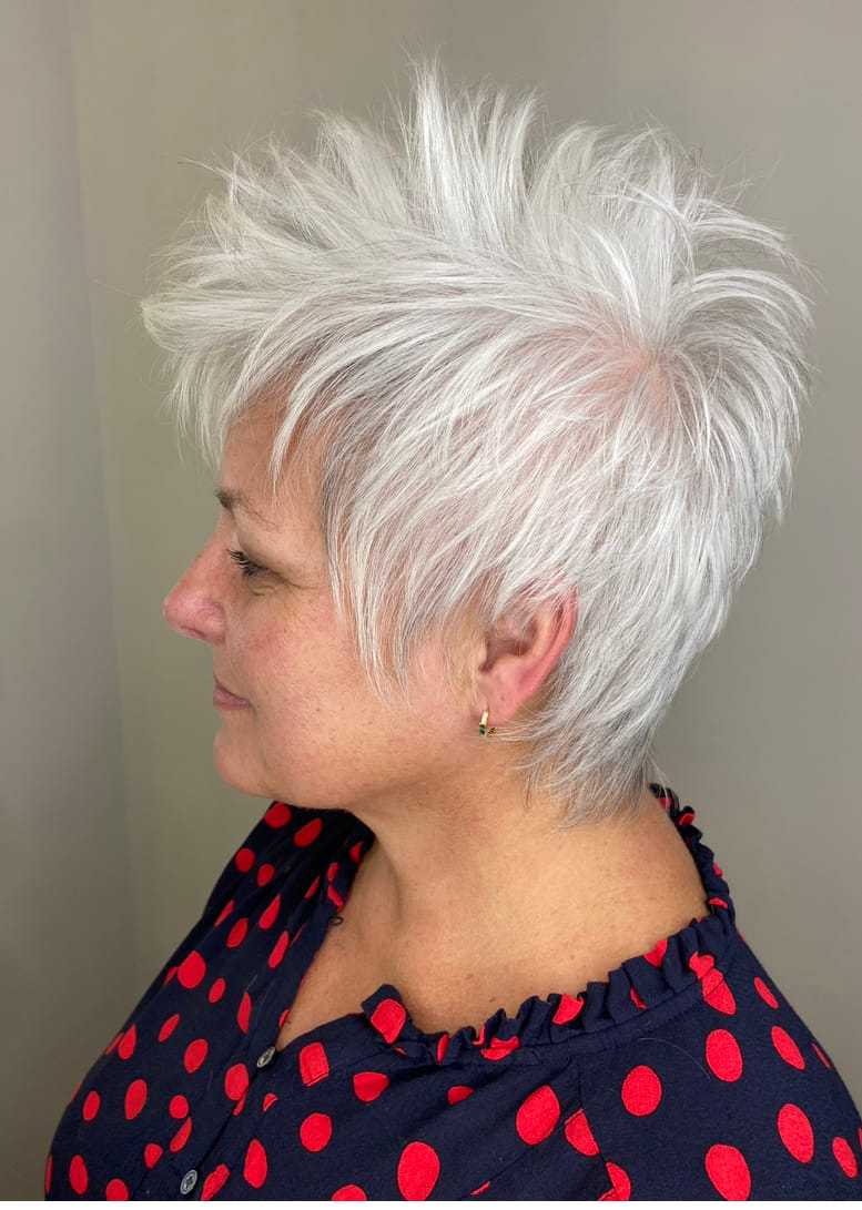 Short spiky white hairstyle on a smiling person in a polka dot shirt.